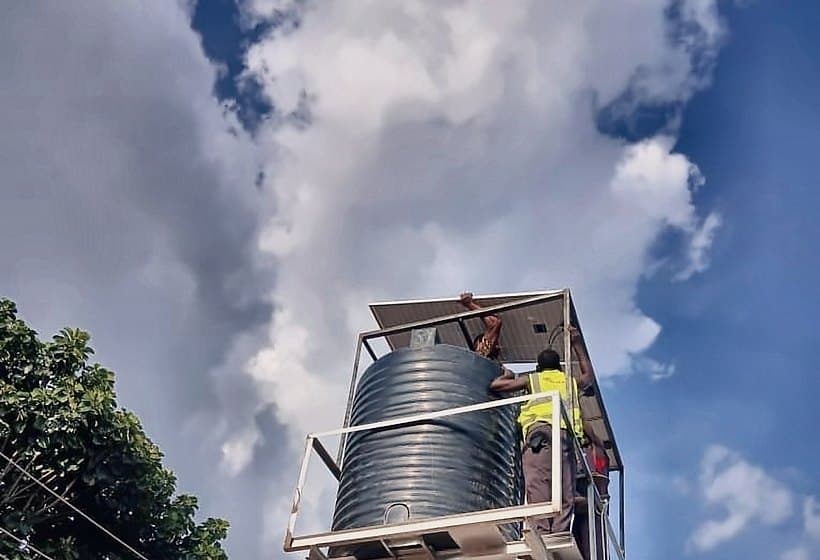The finished tower against open sky, a technician securing the panel